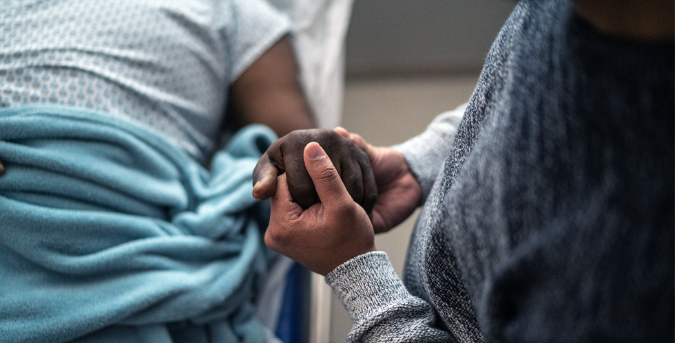 Someone holding a patients hand