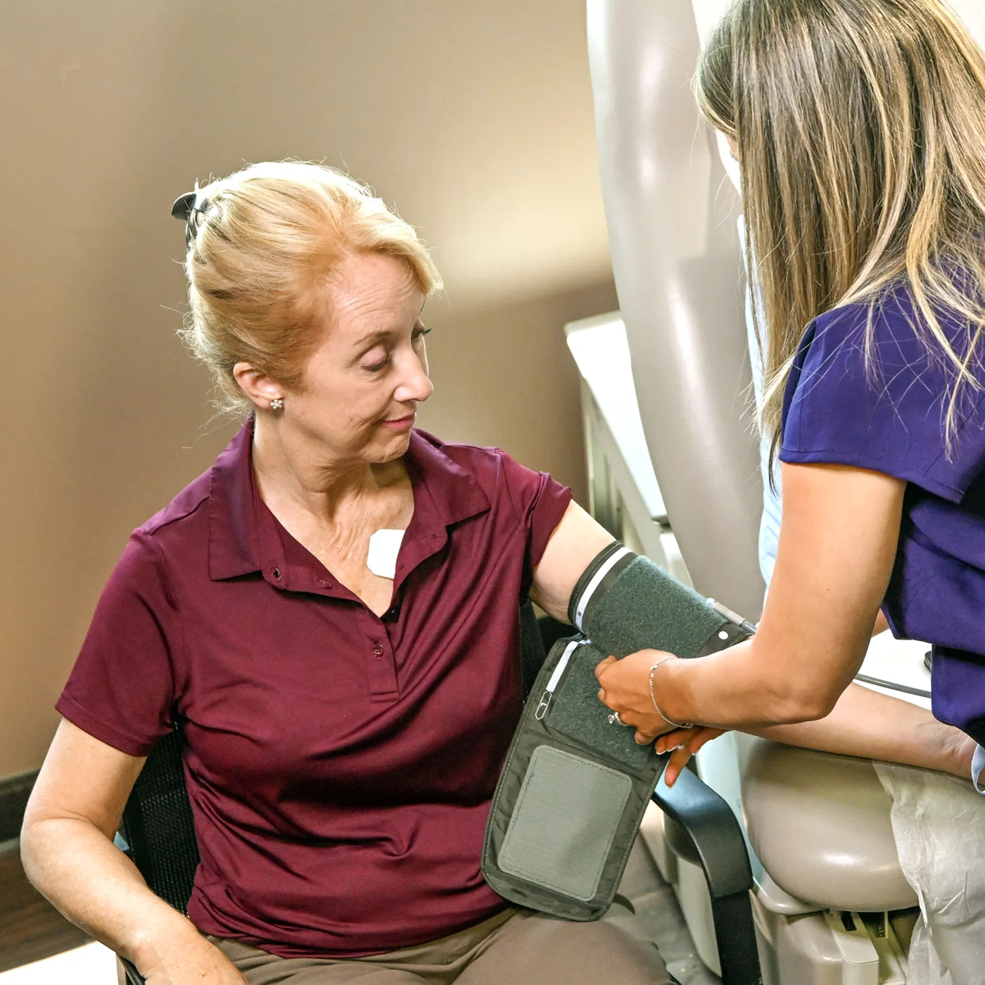 Clinician applying the Vivio System arm cuff to a patient to begin a non-invasive heart failure diagnostic exam.